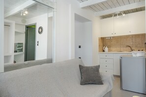 A modern kitchen with a refrigerator, a sink, and a coffee maker.