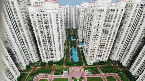 A high-rise residential building complex with multiple floors, a central courtyard, and a swimming pool.