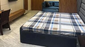 Ein modernes Schlafzimmer mit Bett, Schreibtisch und Fernseher.