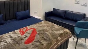 A modern room with a bed, a sofa, and a small table.