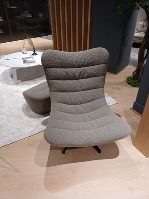A modern armchair with a textured fabric and a unique tiered design, placed on a light-colored floor with a white rug. - Charming studio in the heart of A Coruña (A Coruña)