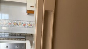 Une cuisine avec des armoires blanches, un dosseret carrelé et un four en acier inoxydable.