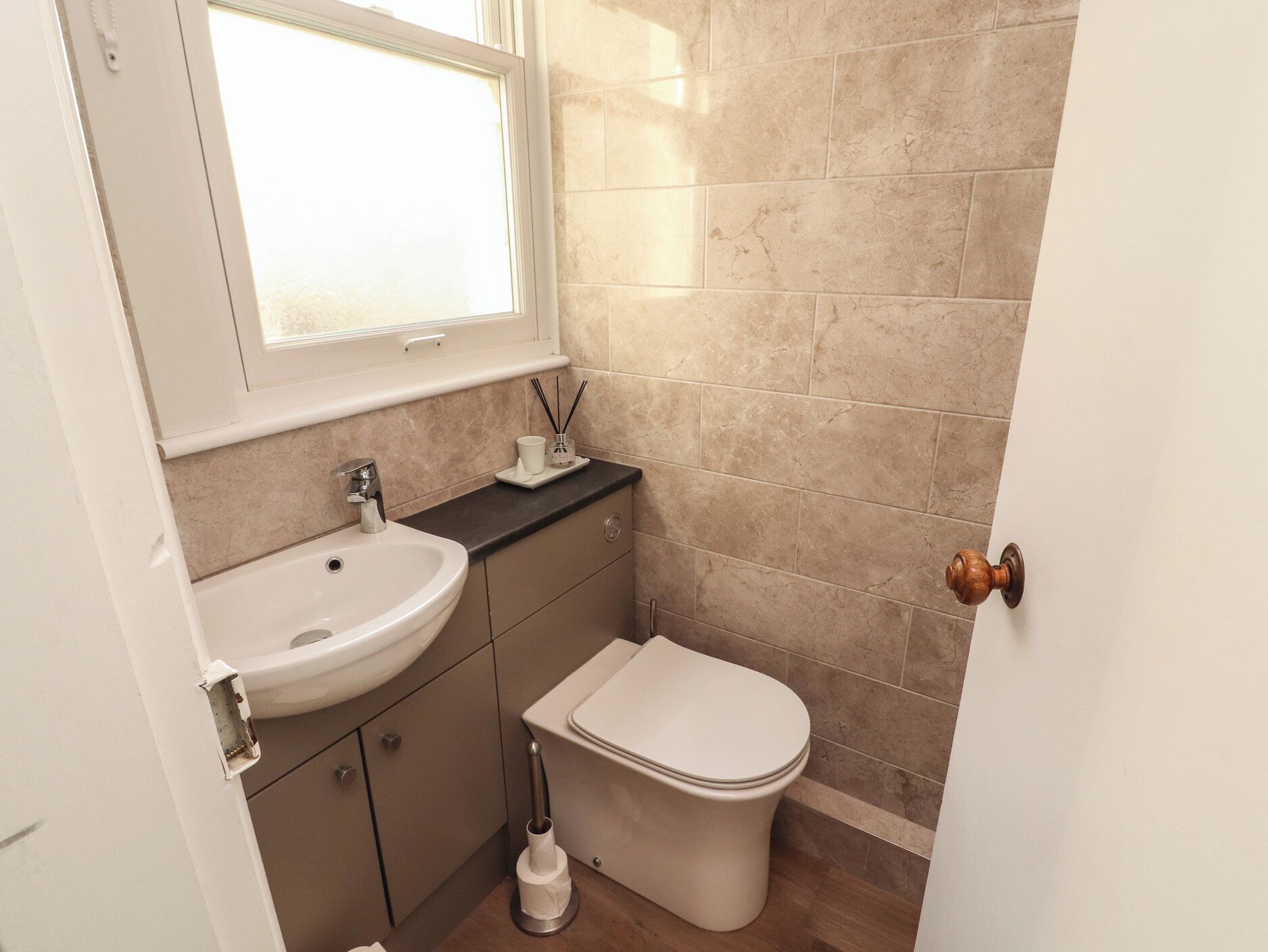 A bathroom with a sink, toilet, and window.