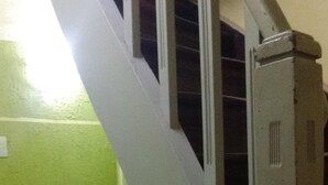 A staircase with metal handrails and a door with a vent. - Hostel Sapucali (Rio de Janeiro)