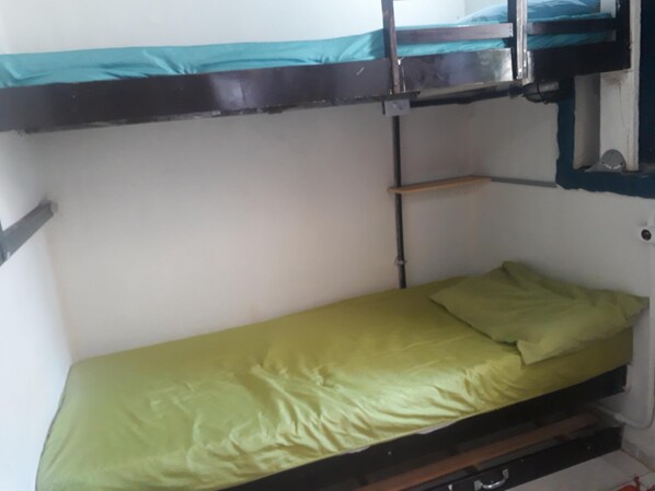 A bunk bed with a green mattress and a single bed below. - Hostel Sapucali (Rio de Janeiro)