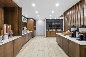 A modern kitchen with wooden cabinets, a tiled backsplash, and a coffee station. - Springhill Suites Pittsburgh Airport (Coraopolis)