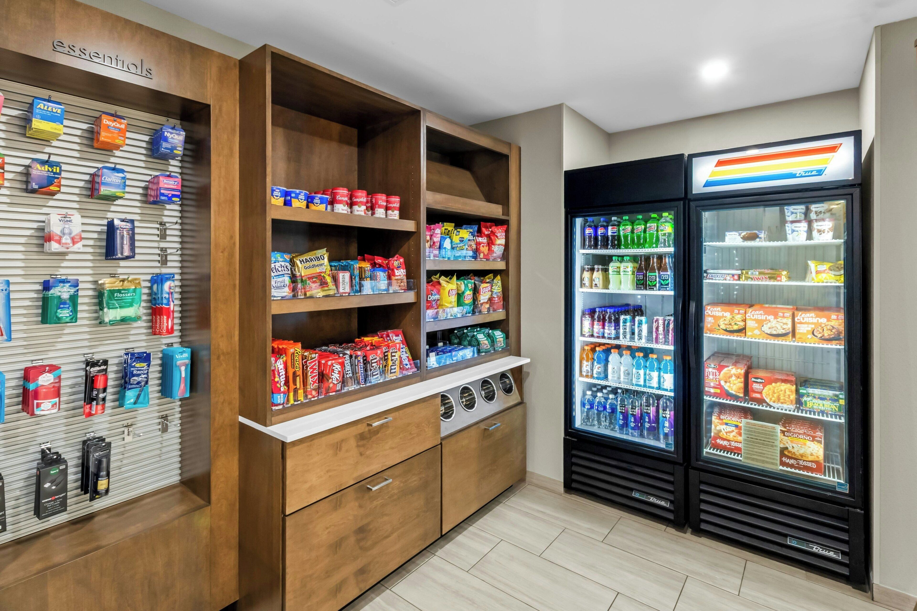 A self-service kiosk with various food and drink options, including refrigerated sections and shelves stocked with snacks and beverages.