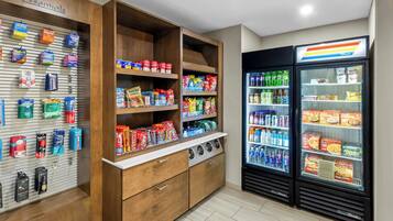 A self-service kiosk with various food and drink options, including refrigerated sections and shelves stocked with snacks and beverages.