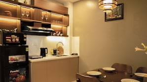A modern kitchen with a dining area, featuring a microwave, stove, sink, and wooden cabinets.