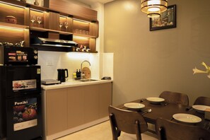 A modern kitchen with a dining area, featuring a microwave, stove, sink, and wooden cabinets.