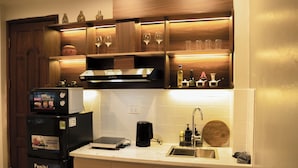 A kitchen with a microwave, refrigerator, and coffee maker.