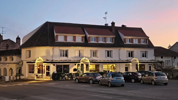 A two-story building with a row of windows on the ground floor and a covered entrance. Several cars are parked in front. - AUBERGE DE LA MARINE (Losne)