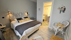 A bedroom with a bed, bedside tables, a chair, and a small table. - AUBERGE DE LA MARINE (Losne)