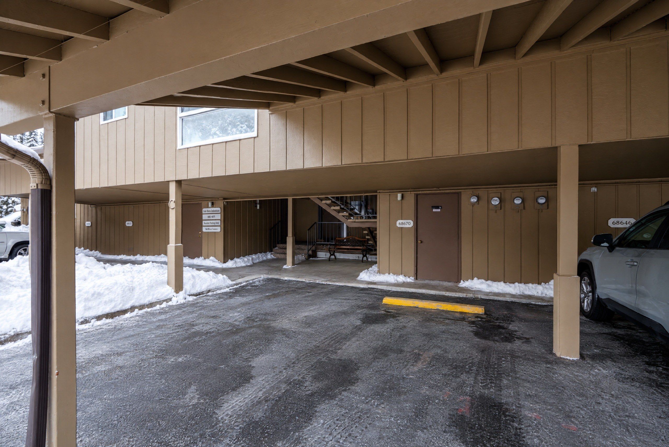 A multi-level parking structure with a covered entrance and a staircase leading to upper levels.