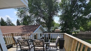 A wooden deck with outdoor furniture and a covered area. - Charming 3-bedroom house with WiFi, in Regin, spacious, calm and lovely space  (Regina)