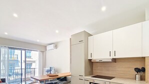 A modern kitchen with white cabinets, a wooden countertop, and a built-in oven.