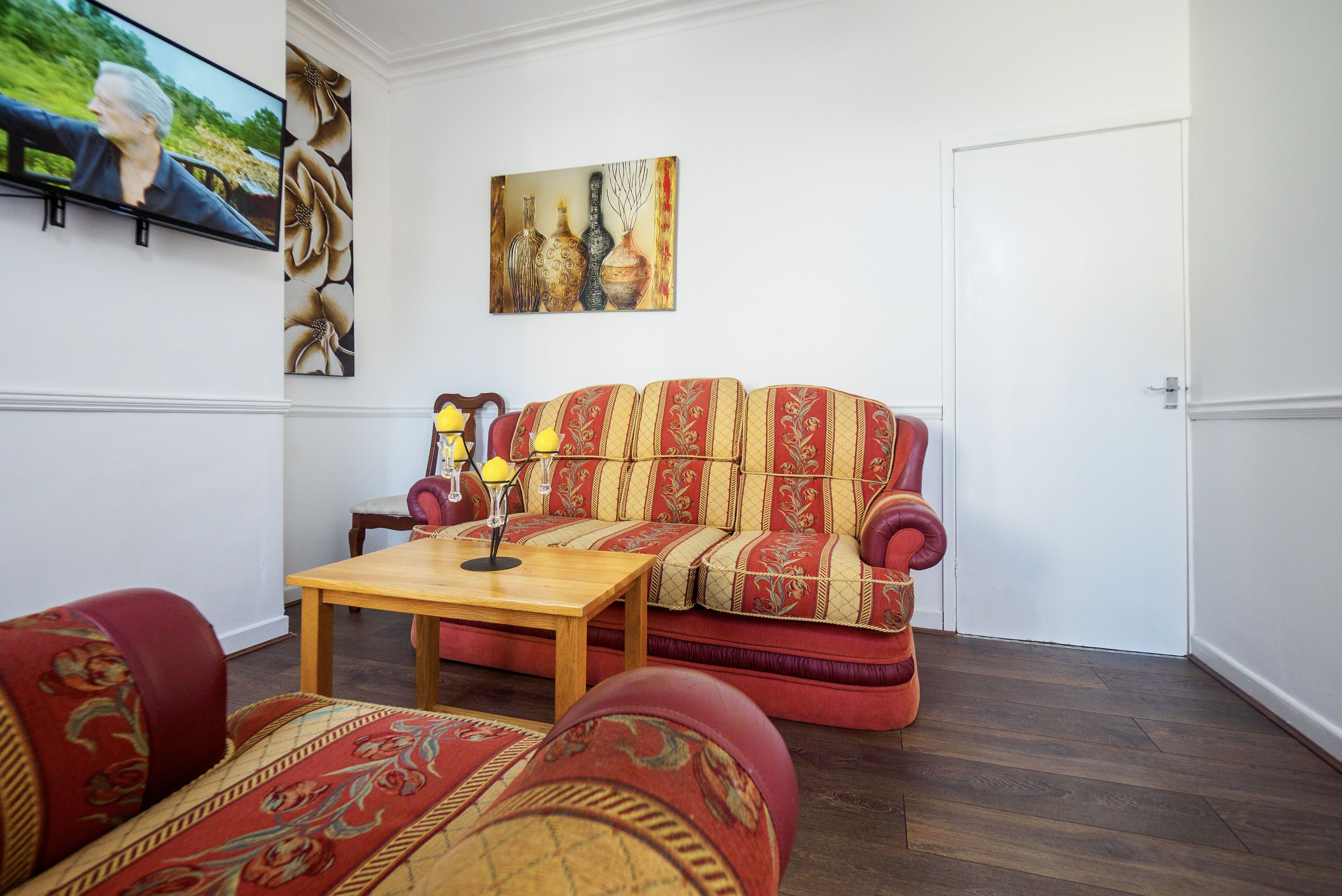 Un salon avec un canapé, une table basse et un tableau accroché au mur.