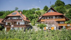 Il s’agit d’un bâtiment de style chalet traditionnel, doté d’un toit en pente, de balcons en bois et offrant une vue dégagée sur les collines environnantes.