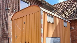 A small, single-room mobile home with a wooden exterior, a small window, and a metal door. - Construction trailer on the farm in the Weserbergland (Coppenbrügge)