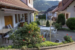 Ein Innenhof mit Essbereich, Topfpflanzen und Blick auf die umliegenden Gebäude.