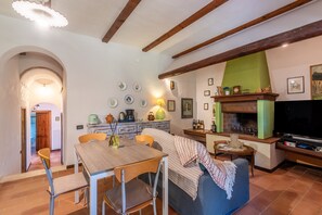 Una sala de estar acogedora con chimenea, comedor y televisor.
