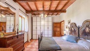 A bedroom with a wooden ceiling, a bed with a headboard, a dresser, and a wardrobe. - "Volpe" Apartment with Pool Reserved for Guests, Wi-Fi, and Air Conditioning (San Gimignano)
