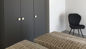 A room with a bed, a chair, and a wardrobe. - Apartment '2 Spätburgunder' with Balcony and Wi-Fi (Freiburg im Breisgau)