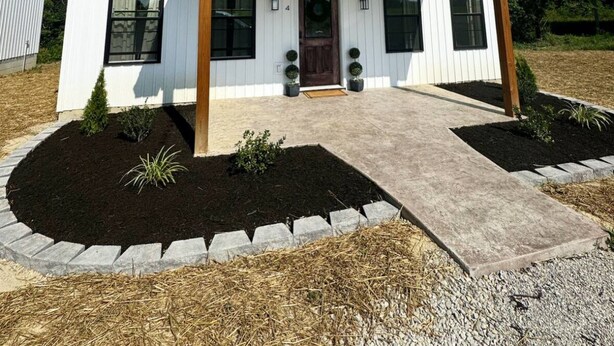 A single-story house with a front porch, a wooden door, and a small front yard with landscaping. - Cottage 4 at MeadowView- near cave run lake! (Morehead)
