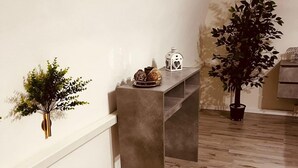 A hallway with a concrete bench, a small potted plant, and a decorative lantern. - Giupa's home (Catania)
