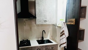 A compact kitchen with a sink, stove, and cabinets. - Giupa's home (Catania)