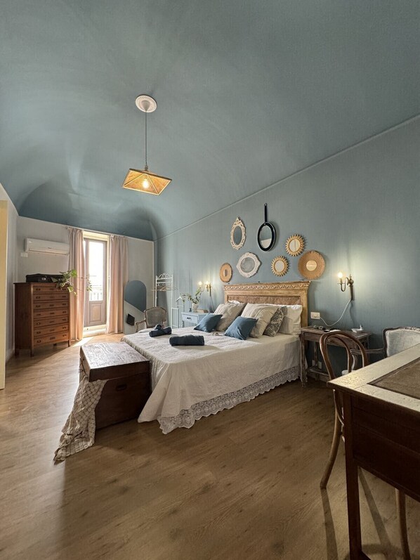 Un dormitorio con cama, mesita de noche, lámpara y adornos en la pared.
