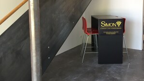 Ein modernes Interieur mit einer Treppe, einem schwarzen Podest und einem roten Stuhl.