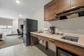 Een koelkast met diepvriezer, een microgolfoven, een kookplaat