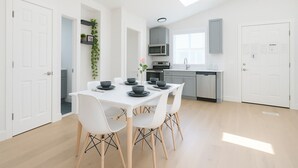 A modern kitchen with white cabinets, a microwave, and a dishwasher. - New Build Smart Home 3 Bedroom (Sunnyvale)