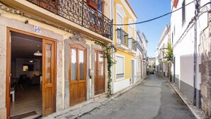 Una stretta via fiancheggiata da edifici, con porte e balconi in legno.
