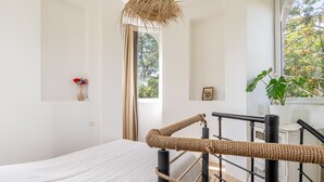 A bedroom with a bed, a window with a view, a plant, and a rope cat toy. - Holiday Home 'Le Moulin De Pen Hoêt' with Shared Garden (Vertou)
