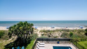 Un espace piscine offrant une vue sur la plage et l’océan.