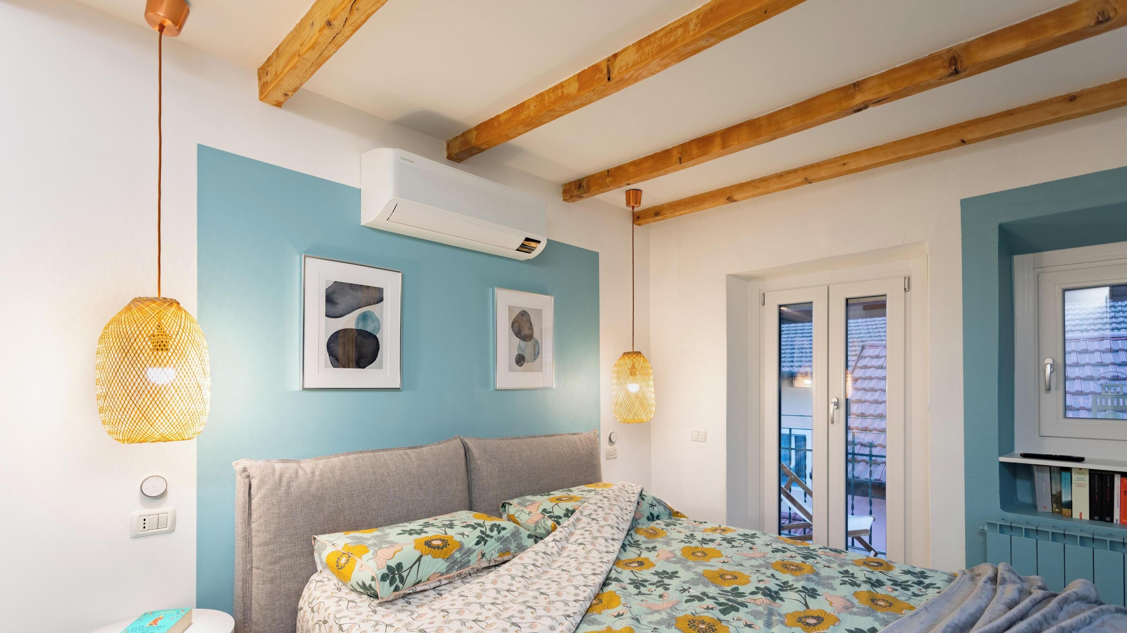 Una camera da letto con un letto, una ventola a soffitto, una finestra e una porta.