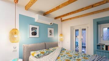 Una camera da letto con un letto, una ventola a soffitto, una finestra e una porta.