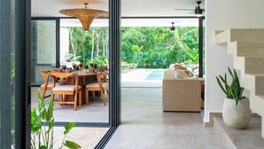 Ein modernes Interieur mit Essbereich, einer Couch und einer Treppe.