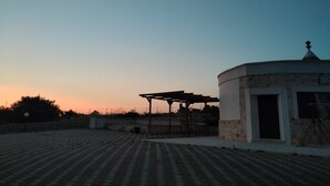 A building with a circular structure and a covered area with a pergola. - Il Trullo di Antonio (Martina Franca)