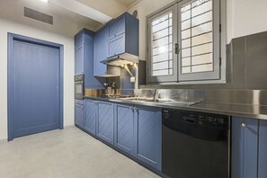 A kitchen with blue cabinets, a stainless steel stove, and a dishwasher. - Apartments Florence - Living in Oltrarno (Firenze)