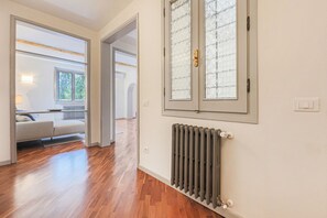 A hallway with wooden flooring, a radiator, and a window with frosted glass. - Apartments Florence - Living in Oltrarno (Firenze)