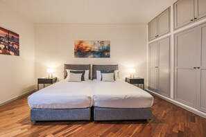 Un lit double avec deux tables de chevet, un tableau au mur et une armoire.