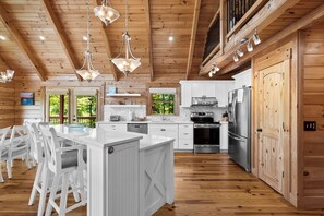 Een ruime keuken met houten kastjes, een centraal eiland en moderne apparatuur.