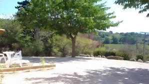 A tree-lined outdoor area with a paved path and a white vehicle. - House "Les Romarins" with Mountain View, Private Pool and Wi-Fi (Bédoin)