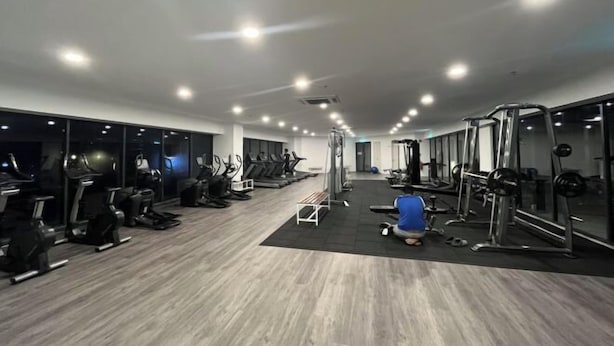 A gym with treadmills, elliptical machines, and weightlifting equipment. - C&Y Horizon Suites Homestay Sepang - KLIA Transit - Near XiaMen University (Sepang)