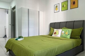 A modern bedroom with a green bedspread, a grey headboard, and two pillows with avocado designs. - C&Y Horizon Suites Homestay Sepang - KLIA Transit - Near XiaMen University (Sepang)