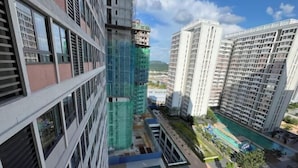 A high-rise building with multiple floors, a swimming pool, and a landscaped area with trees. - C&Y Horizon Suites Homestay Sepang - KLIA Transit - Near XiaMen University (Sepang)