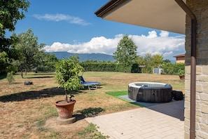 Un espace extérieur aménagé avec un jacuzzi, une pelouse et une vue sur les montagnes.